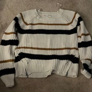 This is a netted sweater that has little zippers on the side